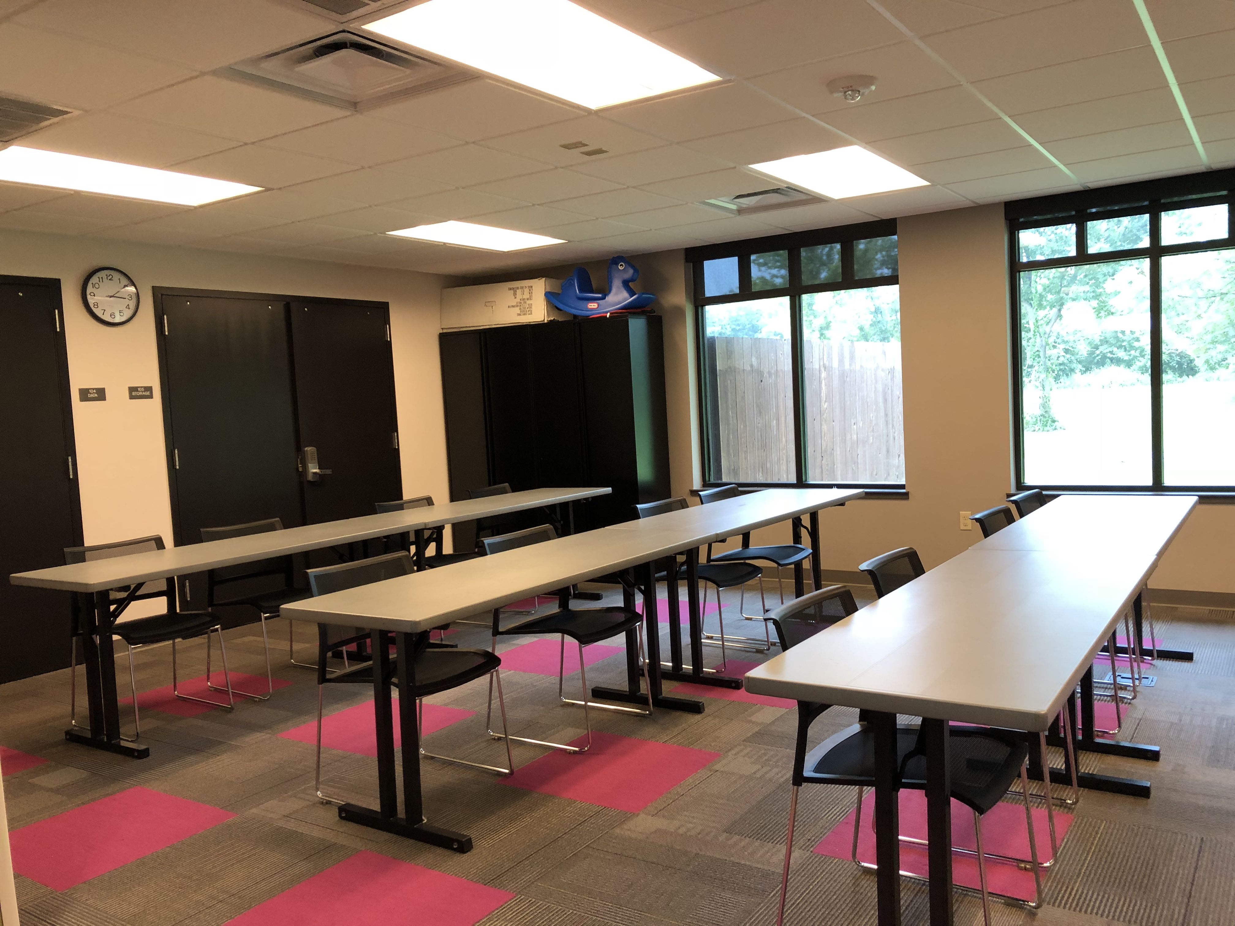 Jones meeting room with three long rectangular tables and four chairs at each table