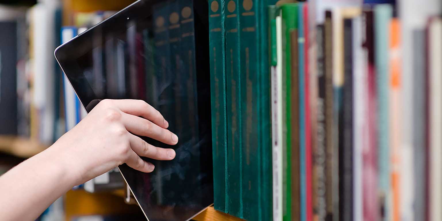 Person pulling an ipad from the bookshelf