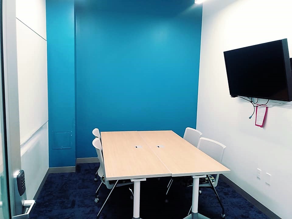 study room with 4 chairs a tv and a whiteboard