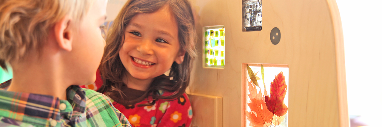 A young girl smiling at a young boy in the library