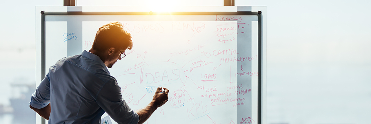 Man writing ideas on board