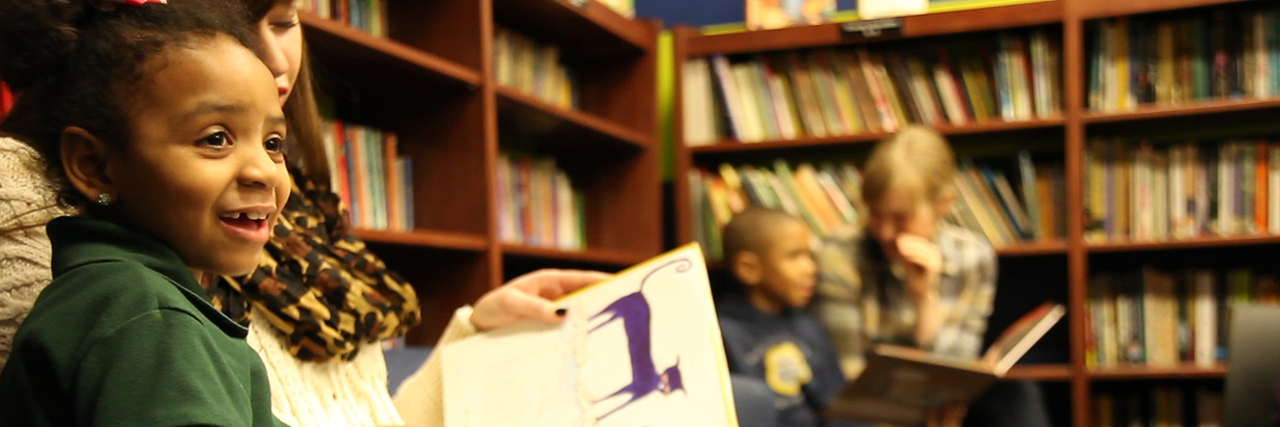 Young girl smiling and looking at book