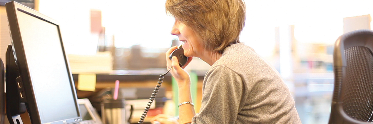 Woman on phone looking at monitor