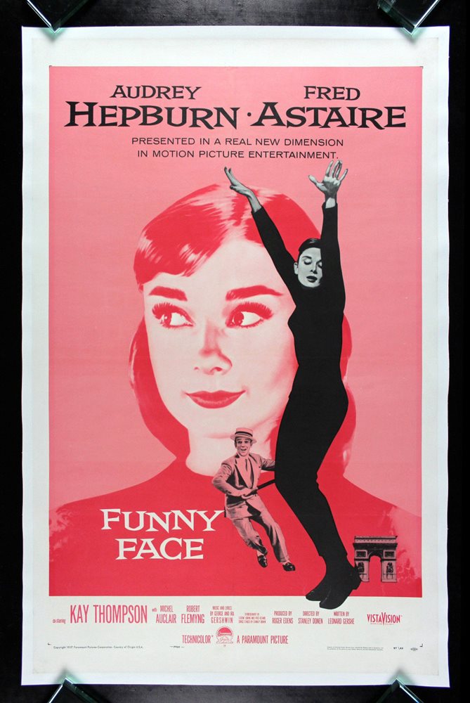 funny face movie poster,pink tinted audrey hepburn in the background smiling, with a black and white dancing audrey in the foreground