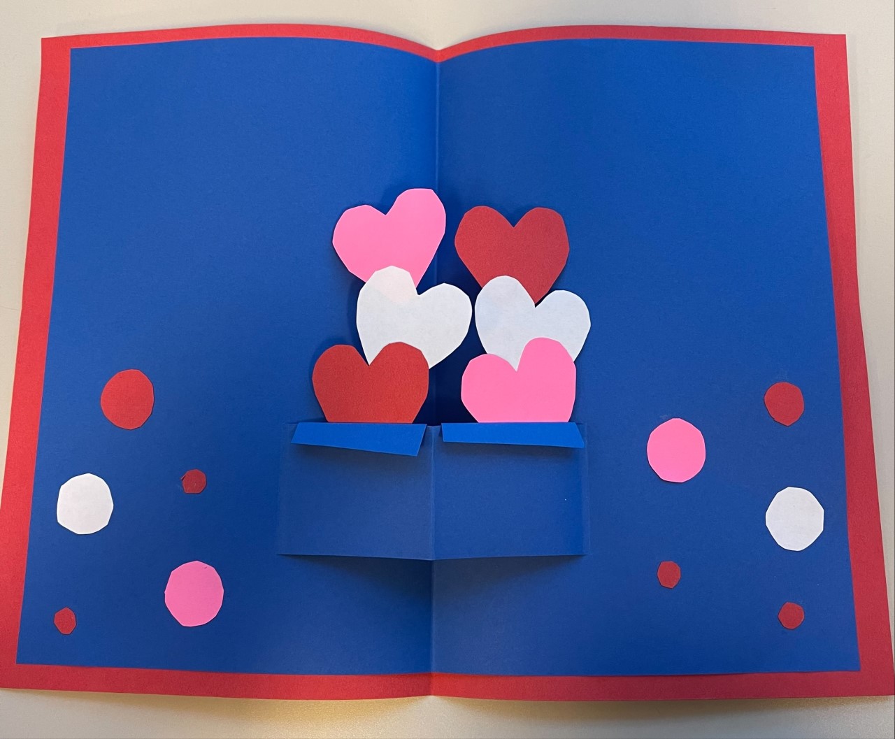 The card's design features hearts exploding from a box.