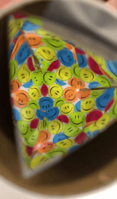 GIF of kaleidoscope with colorful smiley face stickers