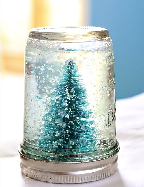 mason jar snow globe with glitter and a miniature evergreen tree