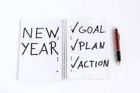 A notebook that says New Year with check marks next to Goal, Plan, Action