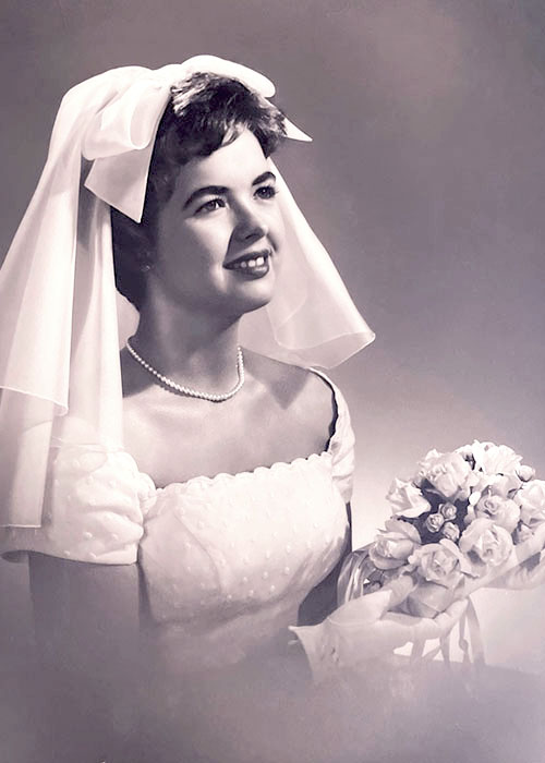 Photographic portrait of an unknown bride in her wedding dress with veil.