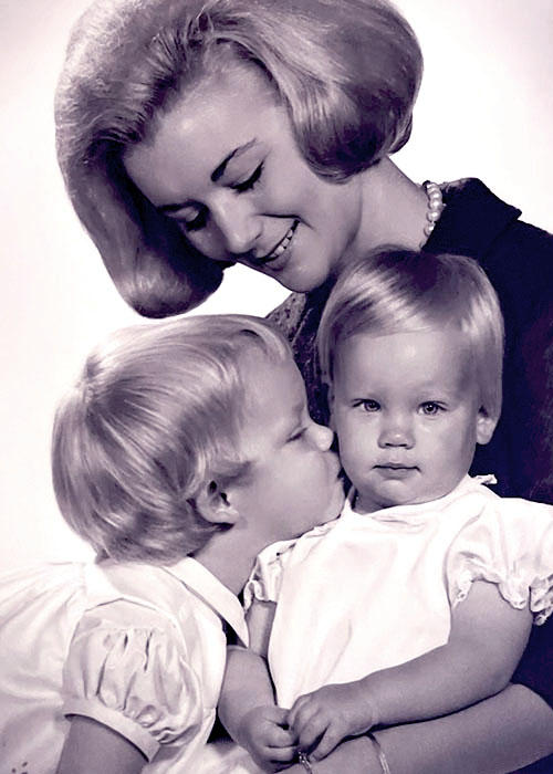 Photographic portrait of a young white mother and her two small children.