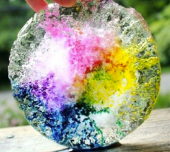 a small circular block of ice with purple, blue, and yellow color inside