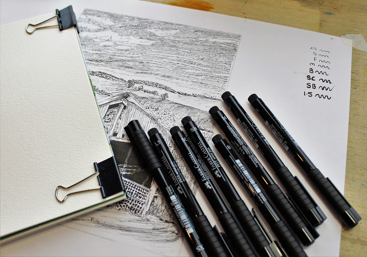 Image of an ink drawing with fine-point pens lying on top of it.