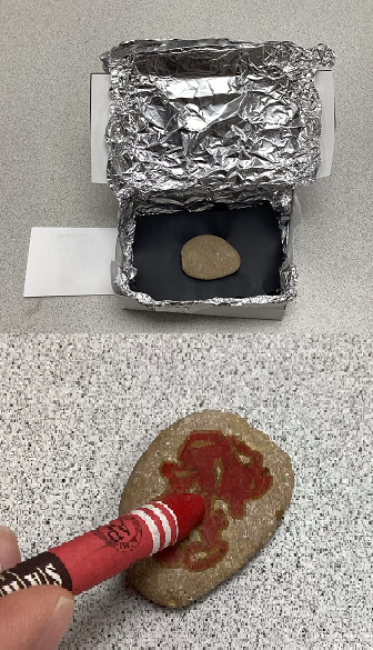 one photo of an open, white cardstock box covered in foil on the inside; it has black paper and a smooth oval rock sitting in it. A second photo below shows the now hot rock being drawn on with a red crayon as the crayon wax melts.