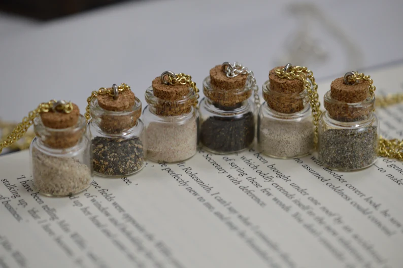 6 mini jars with different sand types on a chain.