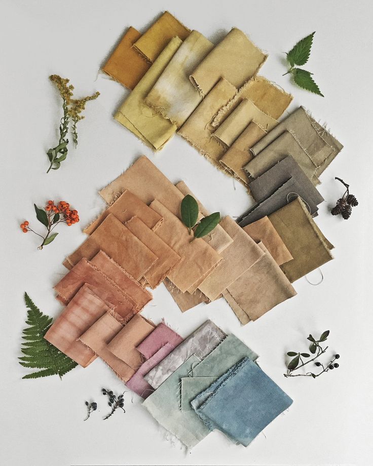 naturally dyed swatches of cloth with herbs around them