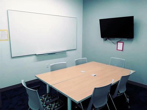 study room with 6 chairs a tv and a whiteboard