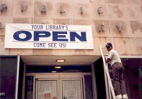 Billy Loudermilk Hangs Sign Announcing the Reopening of the Downtown Library after the Federal Building Bombing