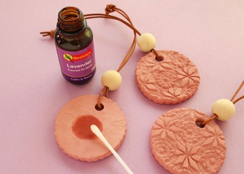 embossed flower terracotta essential oil diffuser discs with lavender oil dabbed on with a qtip
