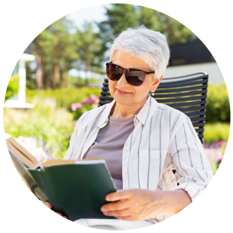 Benefits of Reading - woman reading a book outside with sunglasses on