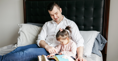 man reading to his child