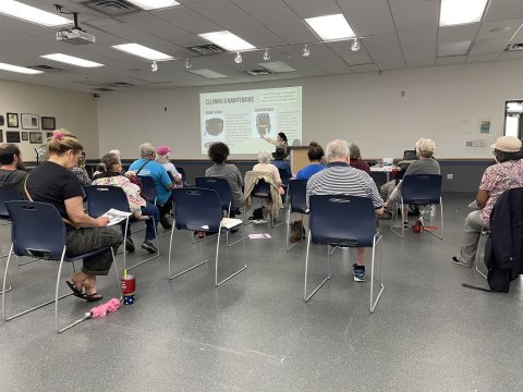 A classroom shows participants watching a presenter
