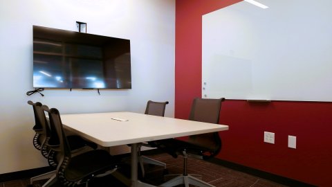 Almonte Library study room with 4 chairs at a table, a whiteboard, and a tv