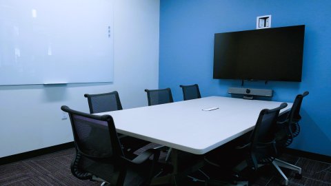 Almonte Library study room with 6 chairs at a table, a whiteboard, and a tv