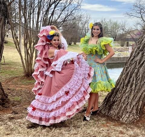 Two women from Clips and Hips standing outside in dresses