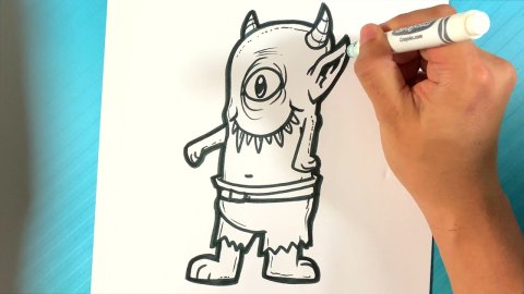 Hand drawing a creature on paper