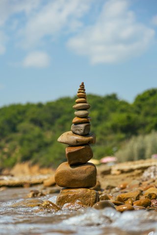 a pile of neatly stacked rock by a waters edge