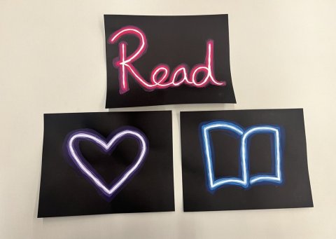 Three examples of faux neon signs on black paper. One says 'Read' in pink, a purple heart, and a blue book.