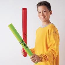 A child in a yellow shirt holding two plastic cylinders called Boomwhackers.