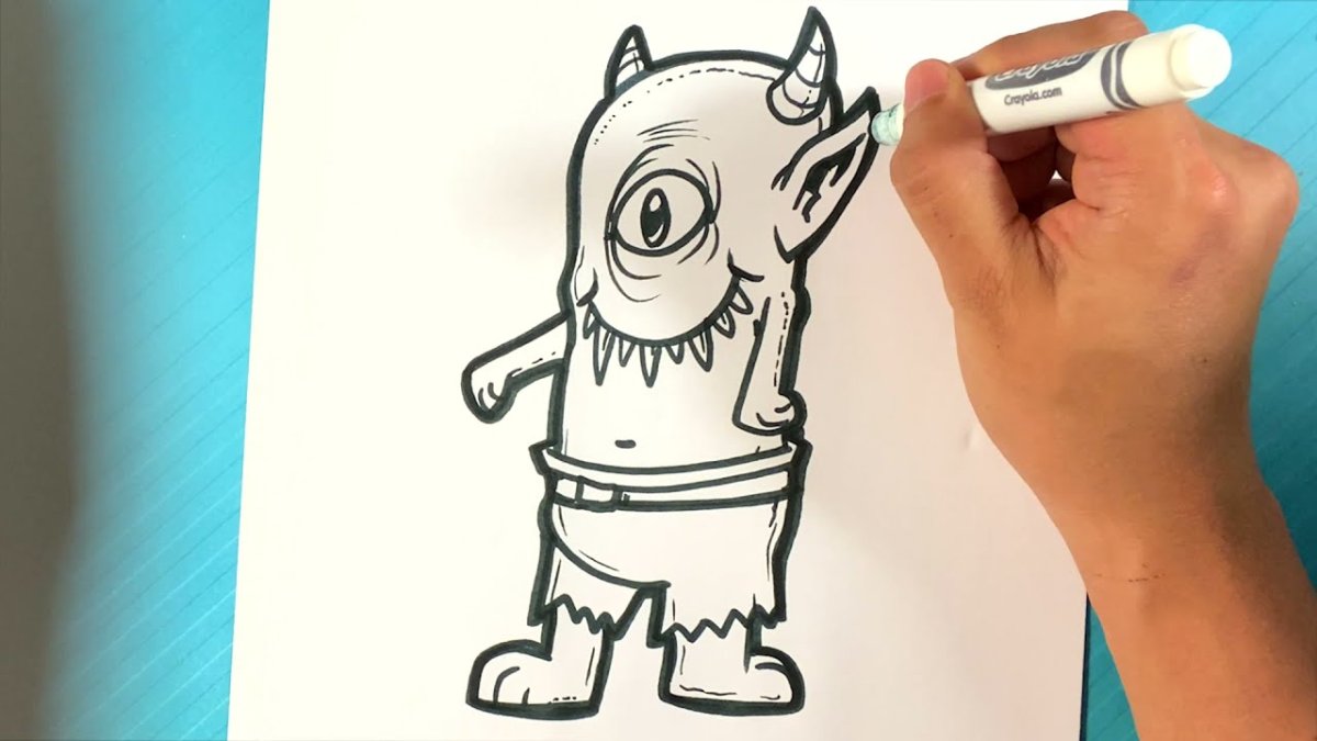 Hand drawing a creature on paper