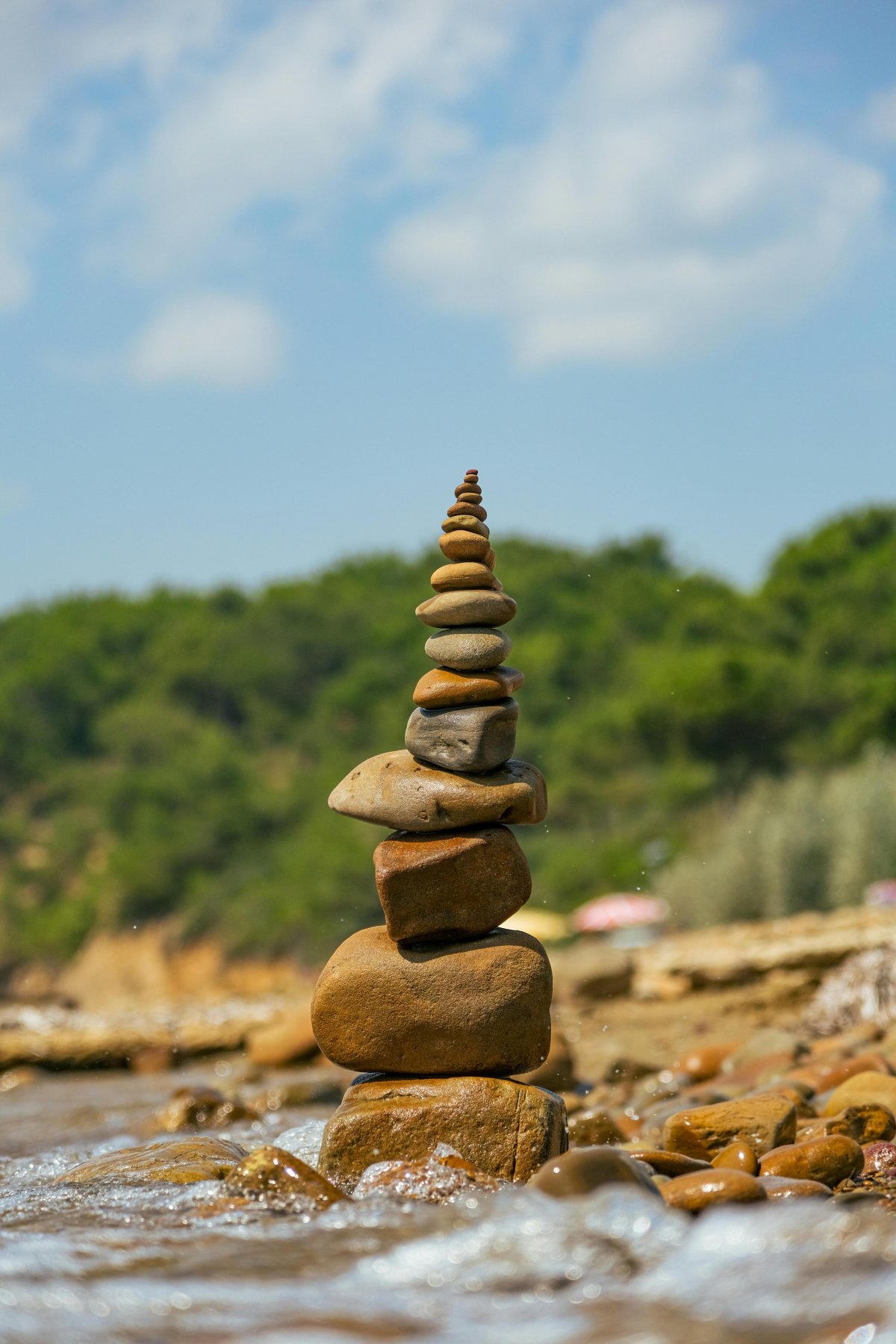a pile of neatly stacked rock by a waters edge