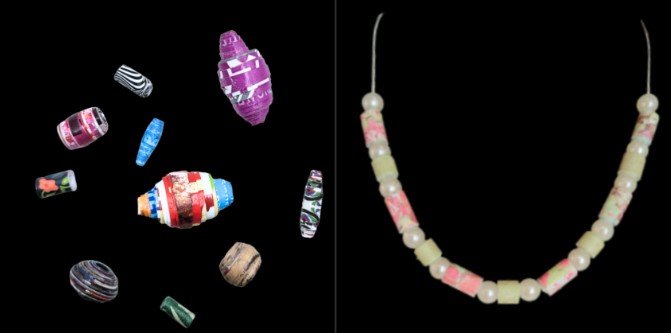 Assorted paper beads next to necklace made with faux pearls and paper beads. 