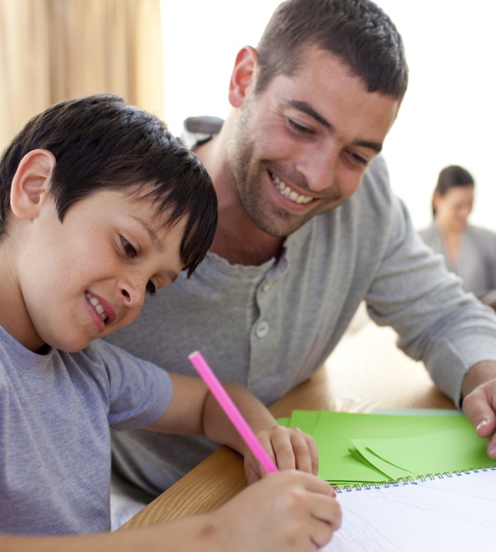 Adult man helping male child with schoolwork