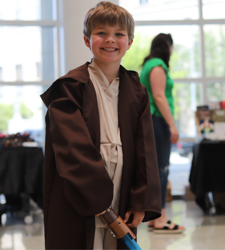 Young boy dressed as a jedi.
