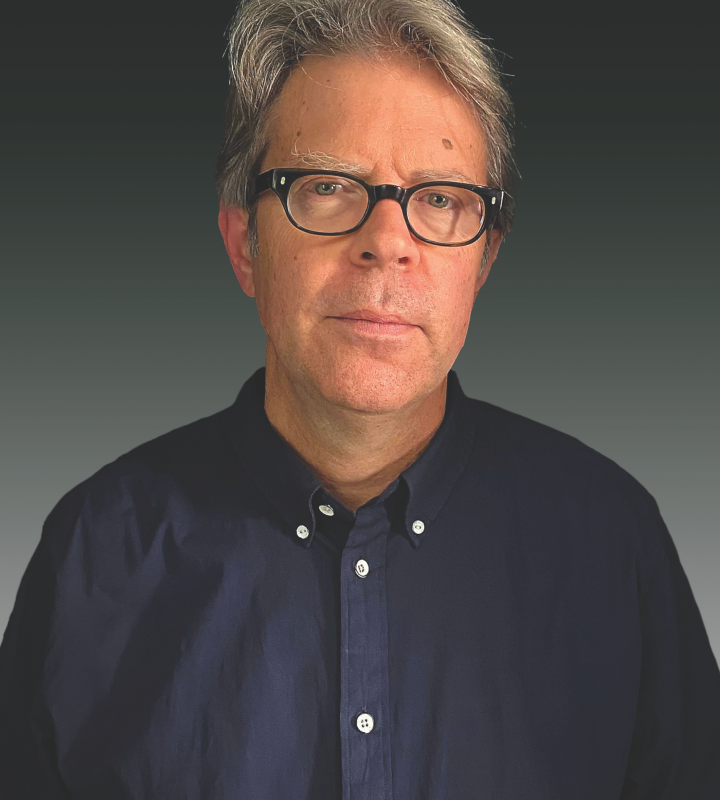Author Jonathan Franzen in a dark button-up shirt against a gray background.